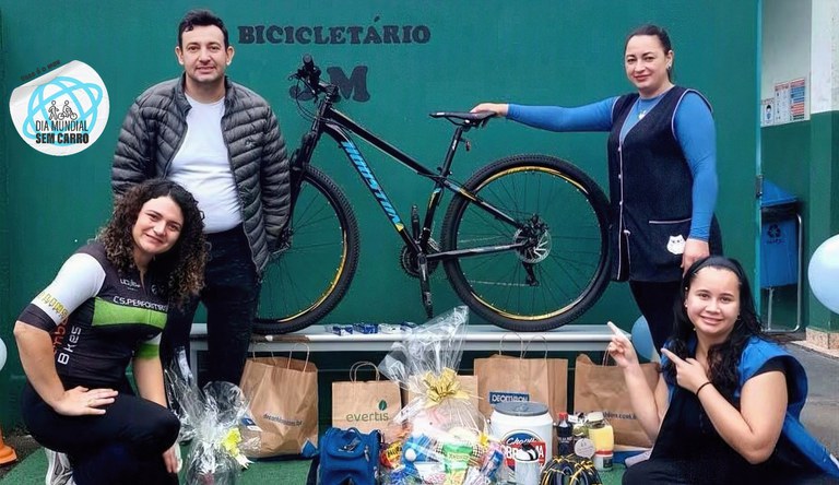 Na foto a professora com mais três colegas juntos a uma bicicleta em um suporte