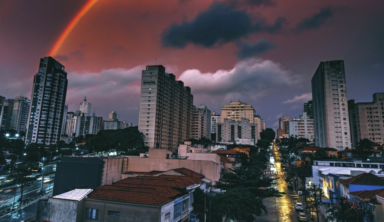 Na foto cidade sob arco-iris ao alvorecer