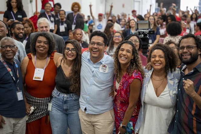 Pessoas sorrindo para fotógrafo em evento na comunidade da Maré, Rio de Janeiro