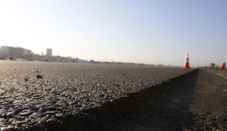 Na imagem vista superaproximada do começo de uma via asfaltada