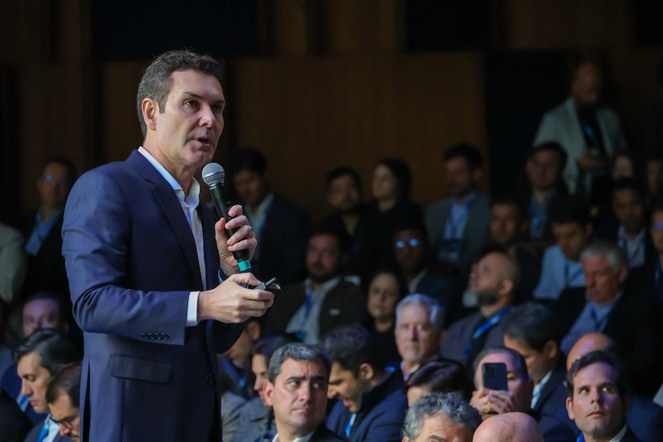 Ministro Jader Filho apresentando dados do programa Minha Casa, Minha Vida em evento do setor imobiliário