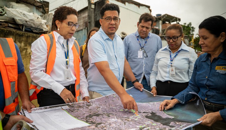 Grupo de pessoas olhando um mapa de uma periferia