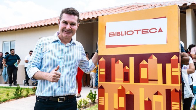 O ministro das Cidades junto à placa da biblioteca