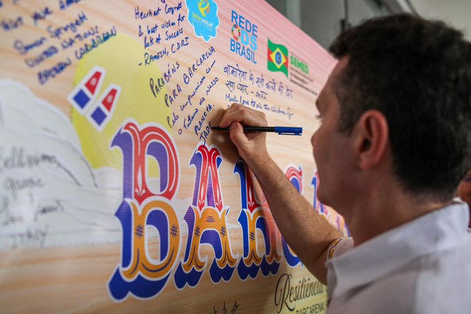 Na imagem, ministro Jader escreve no mural Escola Municipal Checralla Salim Khayathda 