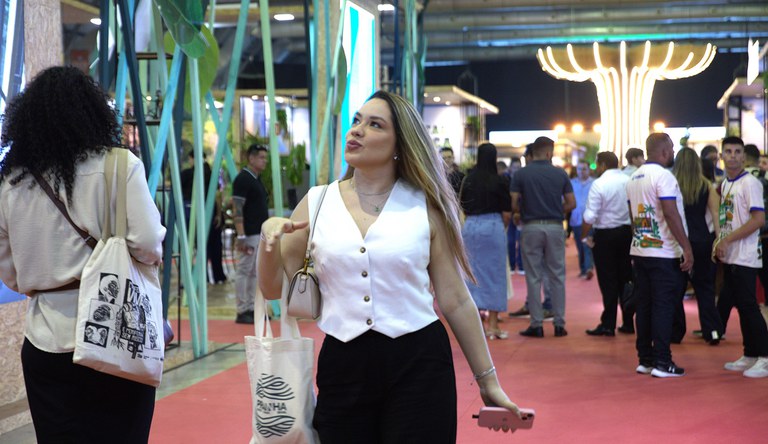 Na imagem, mulher passando em frente ao estande do ministério na COP30