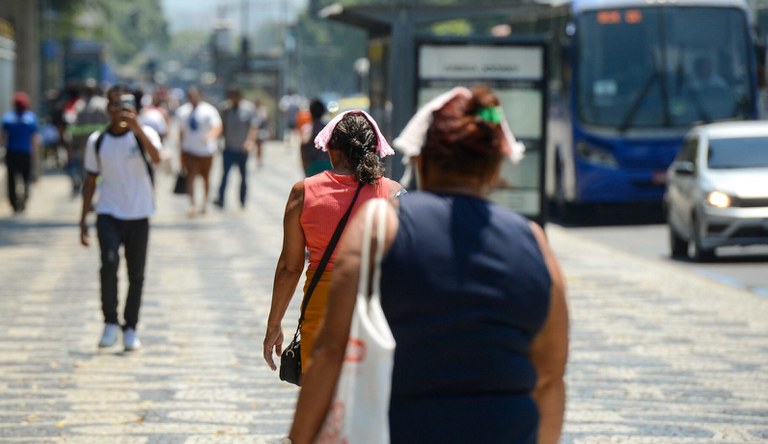 Na imagem, pessoas andando na rua