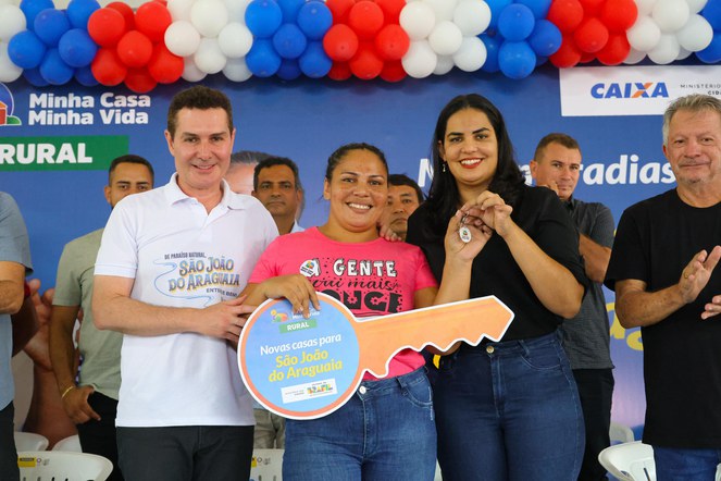 Na imagem, ministro Jader ao lado de beneficiários do programa Minha Casa, Minha Vida.