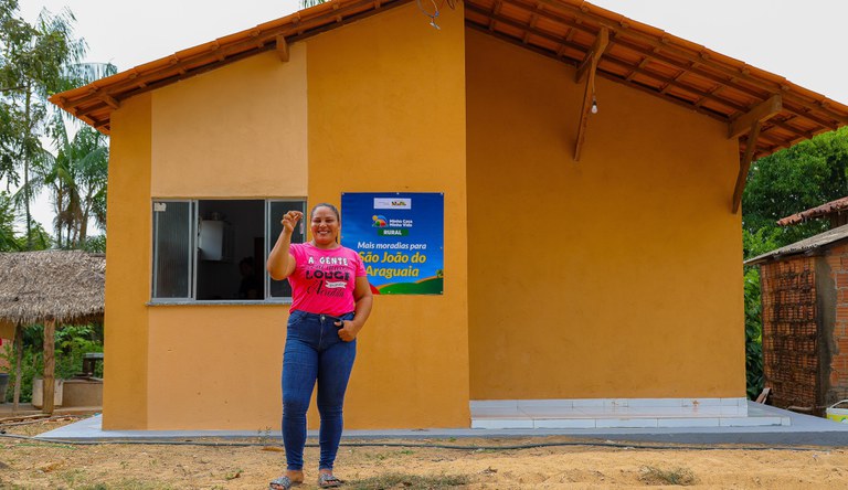 Na imagem, mulher segurando chave da casa