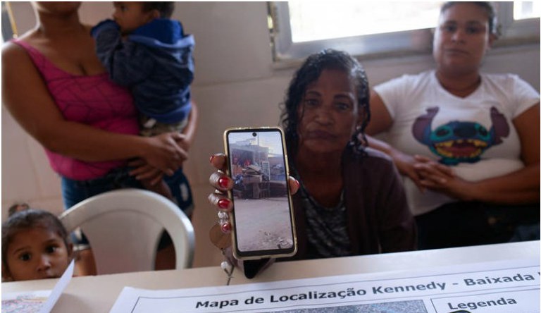 Moradora mostrando destruição da enchente em um celular