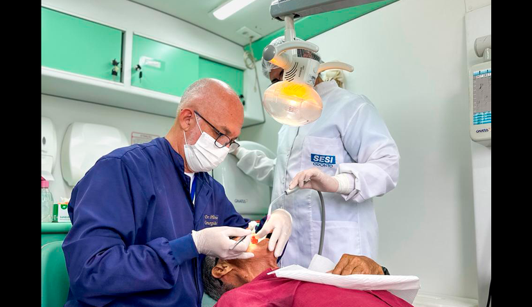 Na foto dentistas tratando um paciente