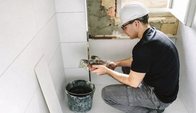 Na foto banheiro sendo reformado por um profissional da construção civil