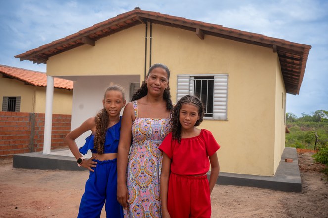 Na imagem mulher ao lado de duas crianças 