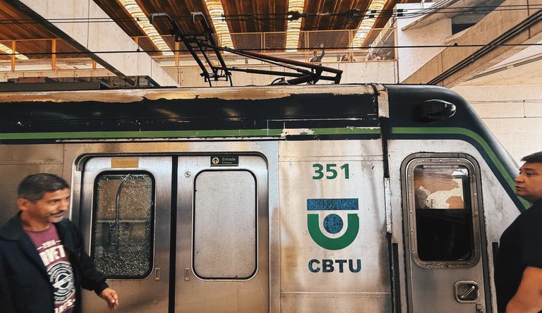Na imagem duas pessoas em frente ao vagão do metrô de Recife