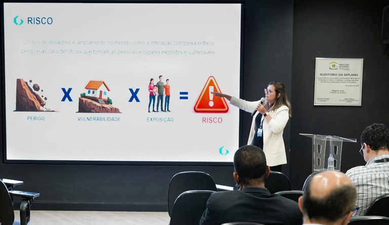 Na imagem mulher apresenta dados sobre programas de periferias do ministério para plateia