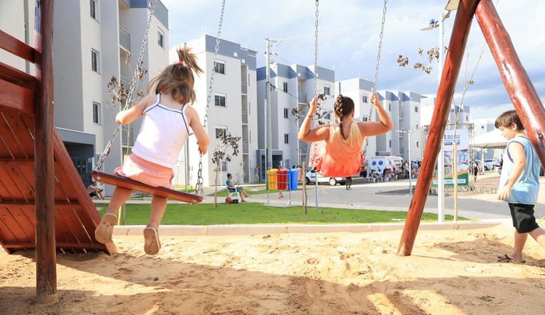 Na imagem crianças brincando no parque de conjunto habitacional do Minha Casa, Minha Vida