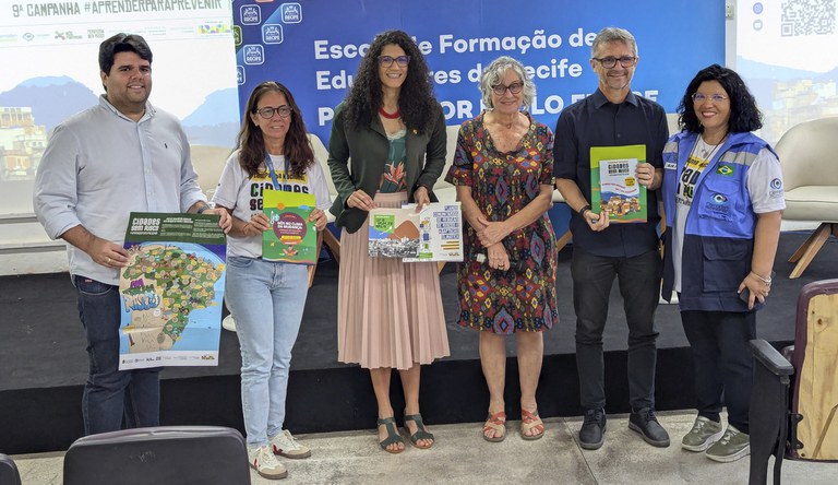 Samia e a equipe exibindo as publicações da Secretaria