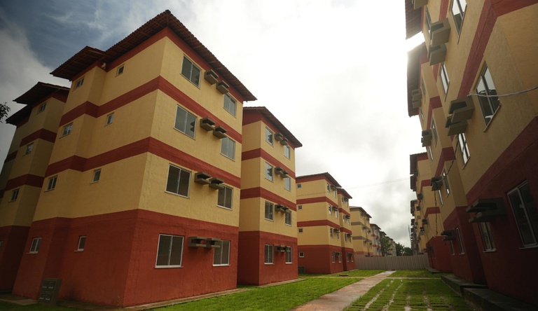 Na imagem residencial Viver Pratinha, o condomínio tem fachada amarela e vermelha.