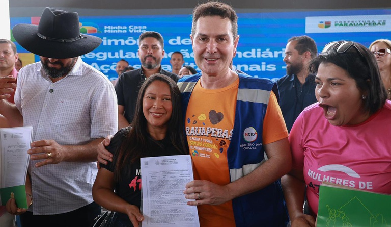 Na foto o ministro das cidades entrega o título para a contemplada