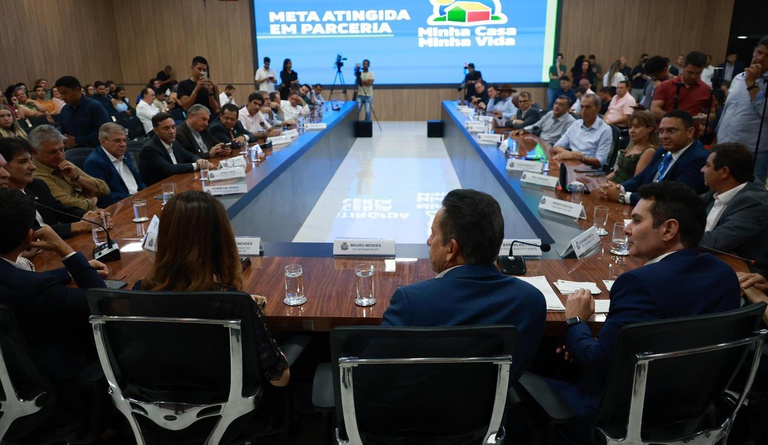 Na foto autoridades reunidas em uma grande mesa em forma de U