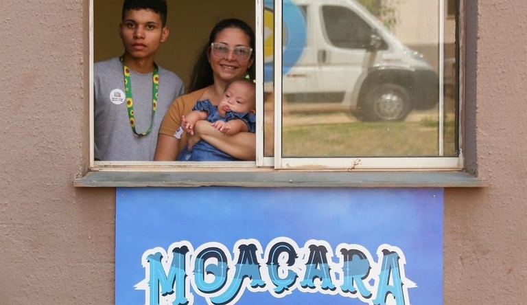 Na imagem mulher segura bebê no colo