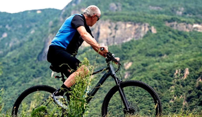 Na imagem homem andando de bicicleta