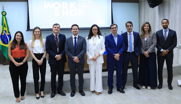 Na imagem pessoas posam para foto durante evento sobre legislação eleitoral.