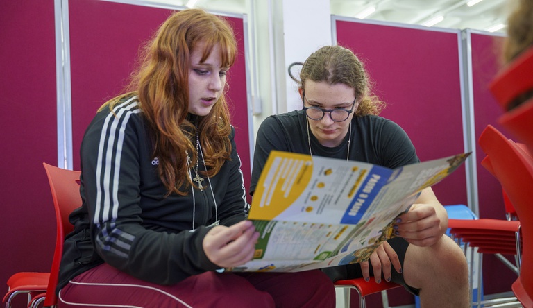 Duas pessoas lendo um folheto