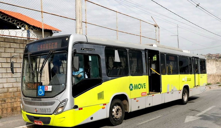 Na imagem foto panorâmica de ônibus amarelo parado na rua