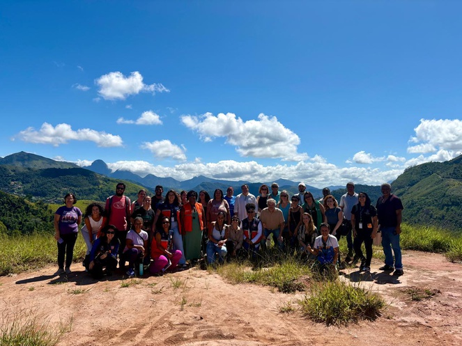 Foto da equipe reunida no alto de um morro