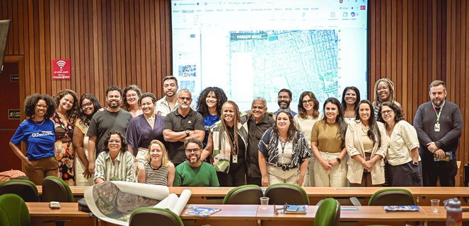 Na imagem pessoas posam para foto durante evento sobre implementação do programa Cep Para Todos em comunidade no Rio de Janeiro.
