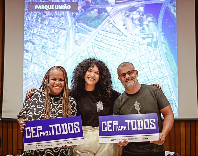 Na imagem duas mulheres e um homem posam para foto segurando placa do Cep Para Todos.