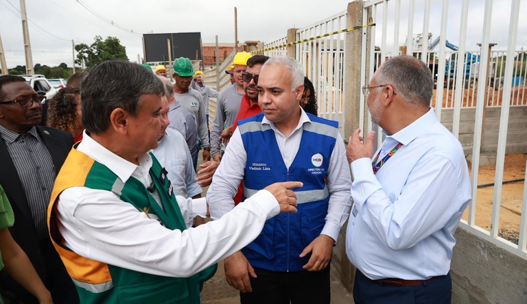 Na imagem homens conversando durante visita ao conjunto habitacional Santa Teresa, Teresina. Ao fundo, trabalhadores da construção civil.