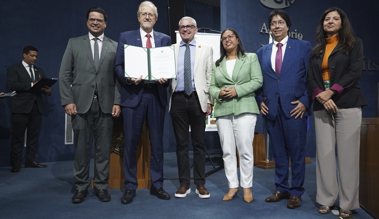 Autoridades do evento exibindo o documento assinado