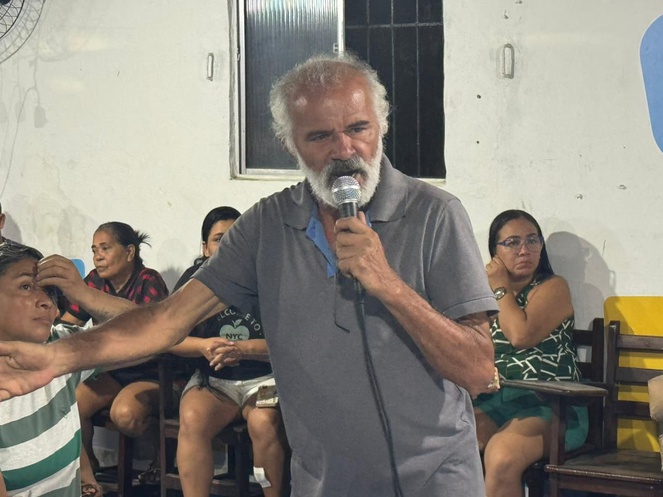 Na imagem homem idoso fala no microfone