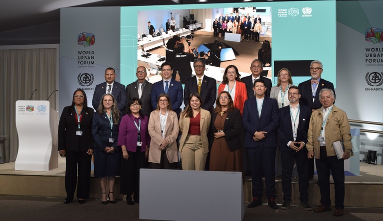 Pessoas reunidas num palco posam para foto