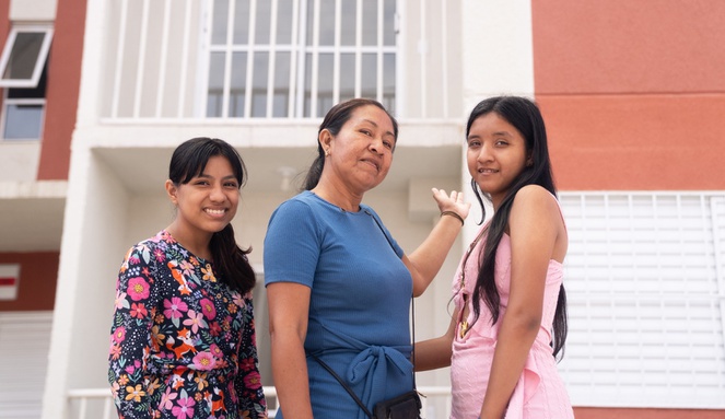 Na imagem família posa para foto em frente a casa nova