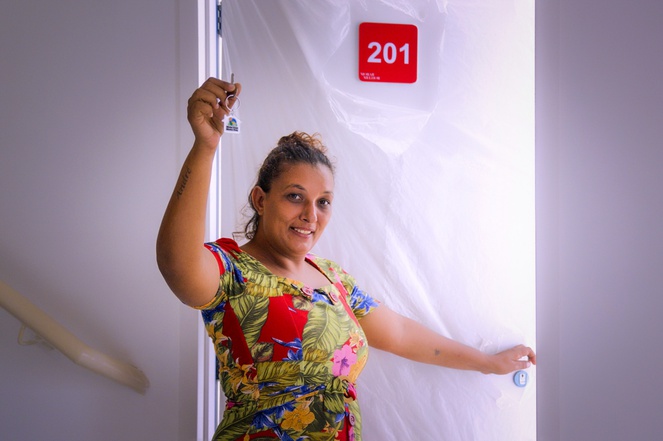 Na imagem mulher segura chave da casa própria