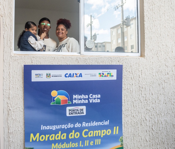 Mais 420 famílias realizam sonho da casa própria em Porto Alegre Na imagem família posa para foto na janela da casa nova