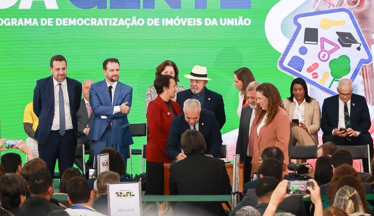 Na foto o ministro das cidades assina documento durante o evento