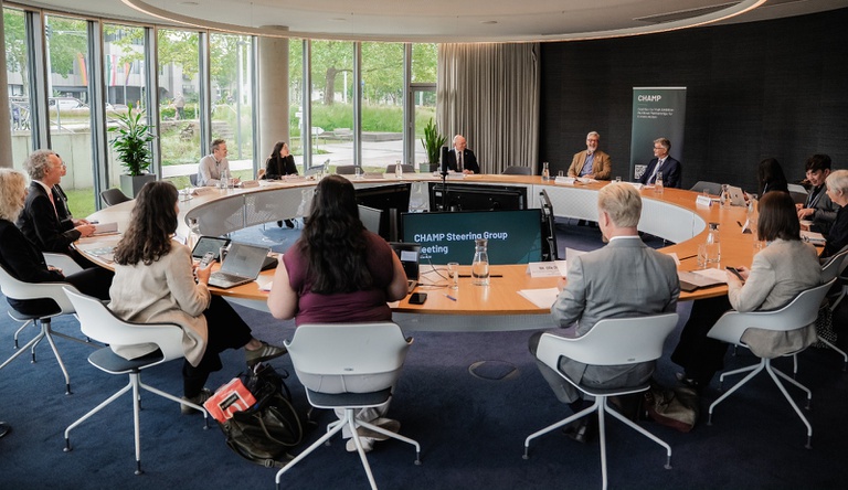 Na imagem grupo de pessoas reunidas numa mesa redonda discutindo ações do meio ambiente e clima