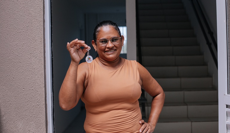 Na imagem mulher segura chave da casa propria