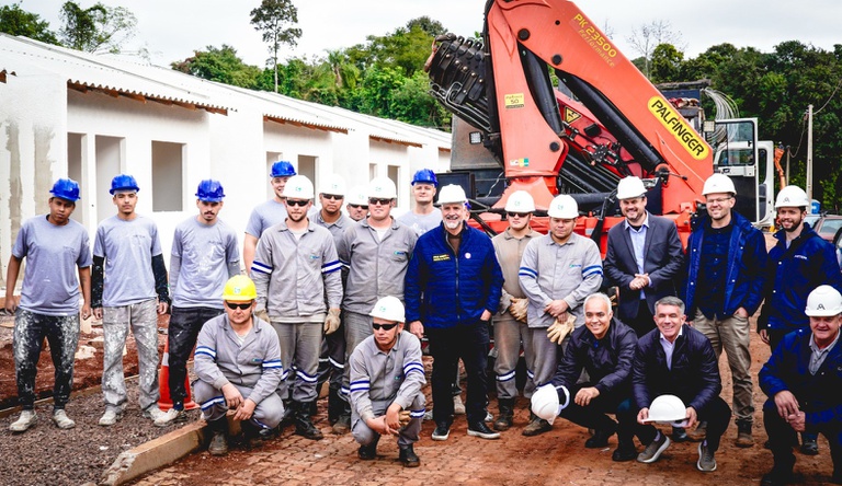 Na imagem ministro das cidades posa para foto com pedreiros de obra de casas no Rio Grande do Sul
