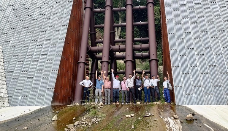 Na imagem homens posam para foto em frente a obra do projeto Sabo