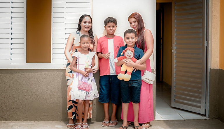 Na imagem família beneficiária de casa do Minha Casa, Minha Vida.