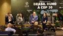 Na foto o ministro Jader Filho ao microfone ao lado de outras autoridades sentados a frente de um painel com os dizeres "Ciclo de Seminários Brasil Rumo a COP30"