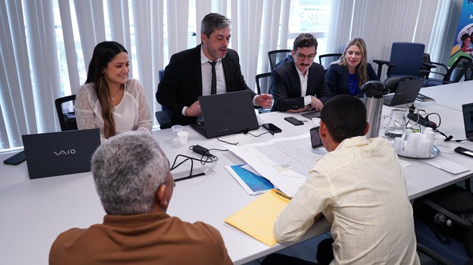 Na foto grupo de pessoas a mesa em reunião com o município de Santos