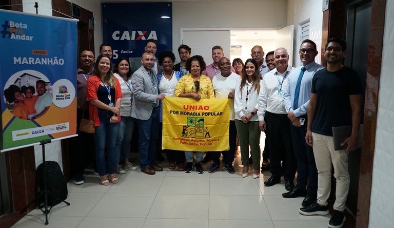Na foto grupo de pessoas com cartaz com os dizeres "união por moradir popular"