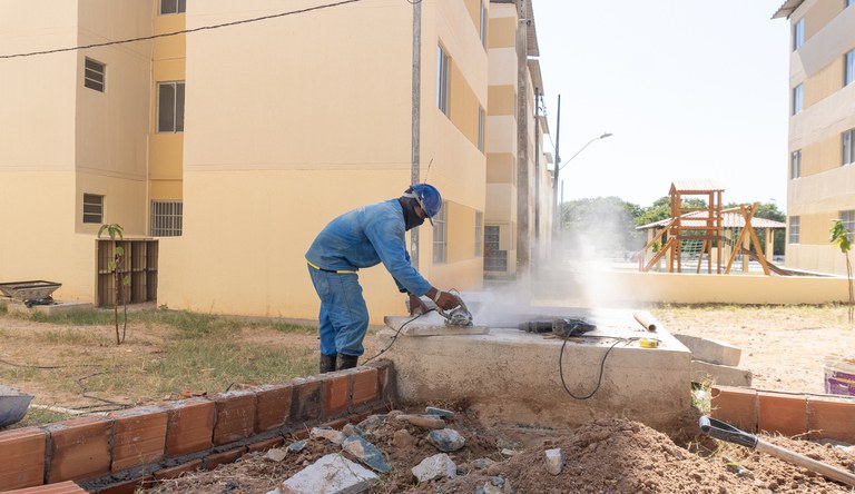 Na foto trabalhador da construção civil utilizando ferramenta de corte em uma das obras do MCMV
