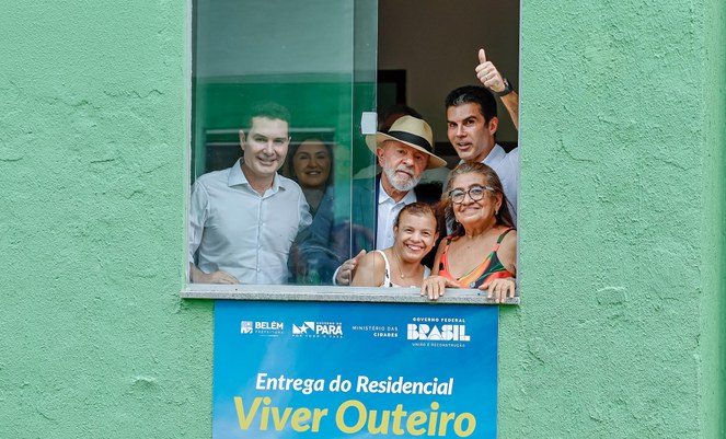 Na foto o ministro Jader Filho, o presidente Lula e o governador Hélder Barbalho, na janela de uma das unidades habitacionais com outras pessoas