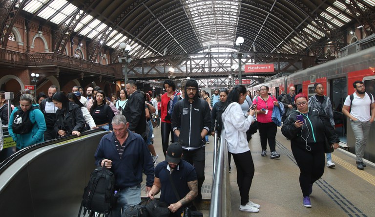 Na foto pessoas circulam e aguardam por trem em uma estação de metrô